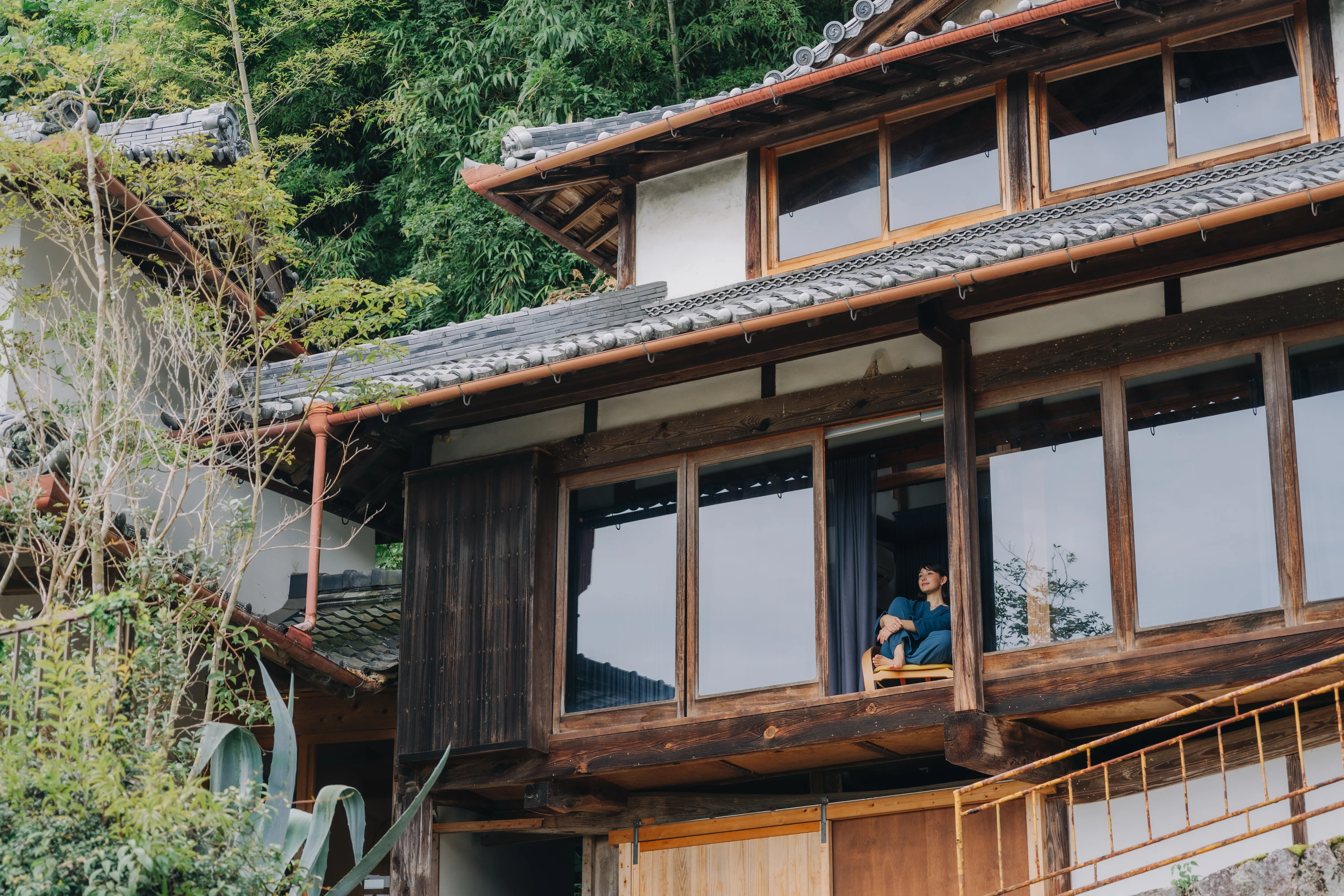 窓辺に人の姿が見える母屋の外観