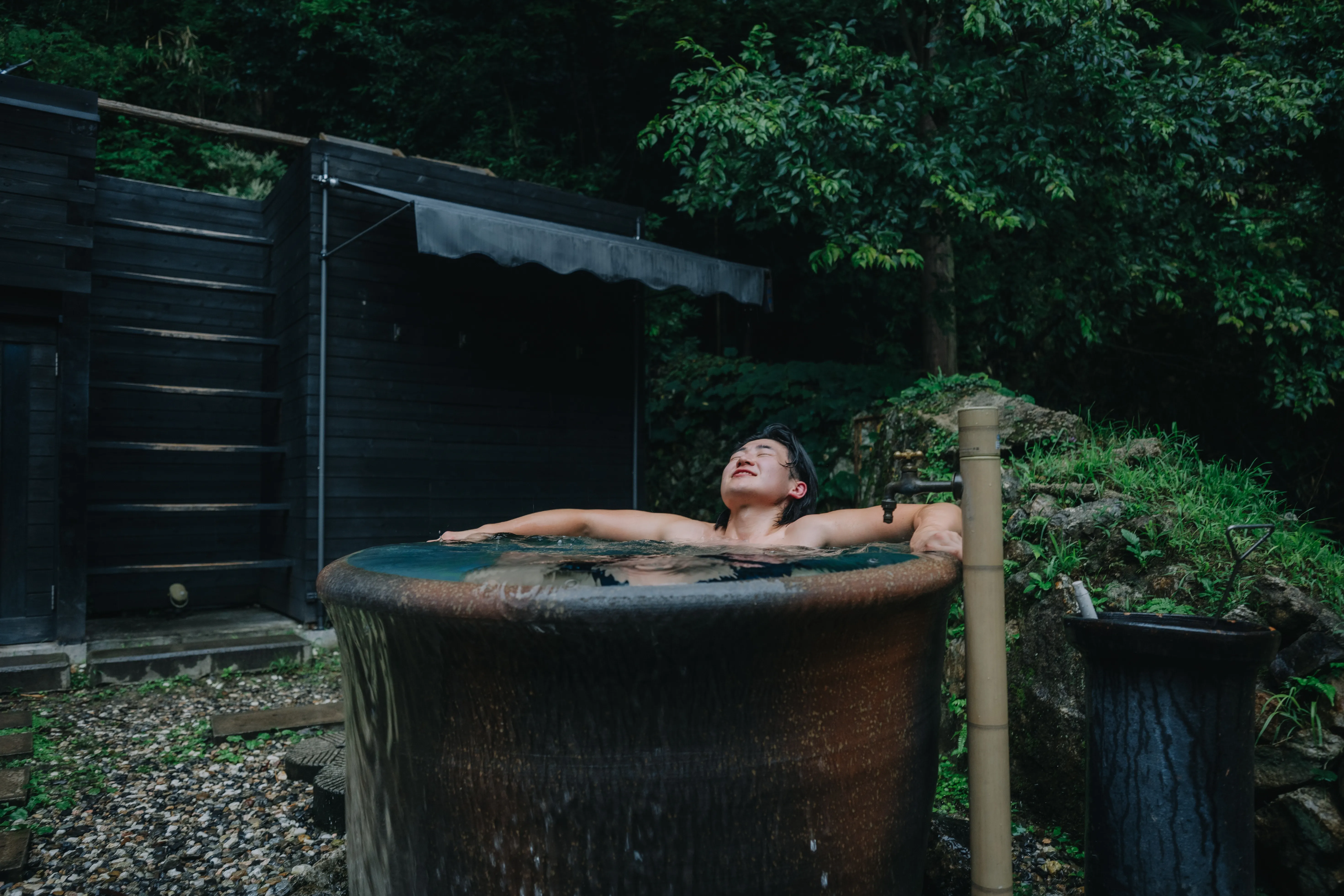 屋外の水風呂に身を沈める人