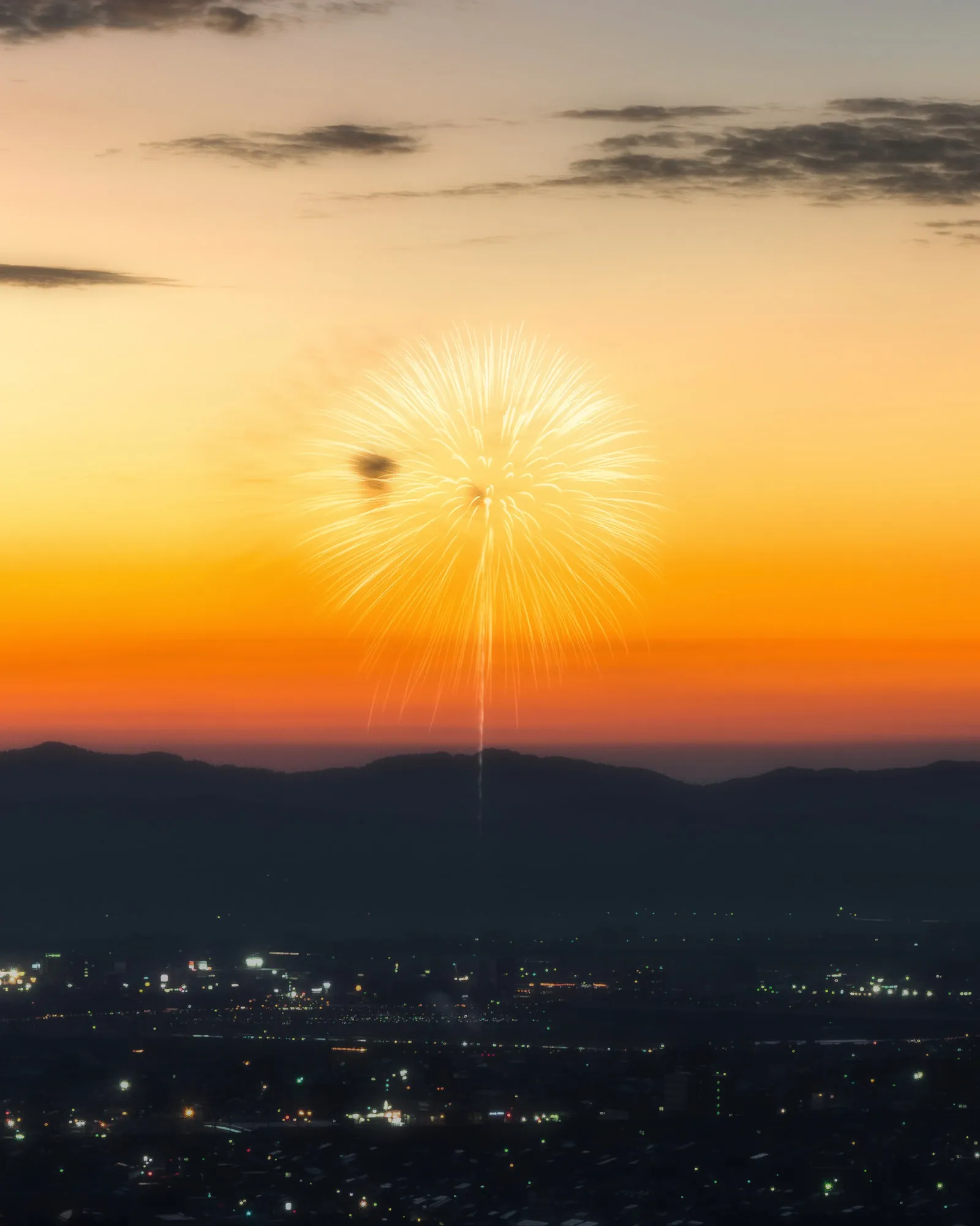 夕焼けの空に開いた一発の花火