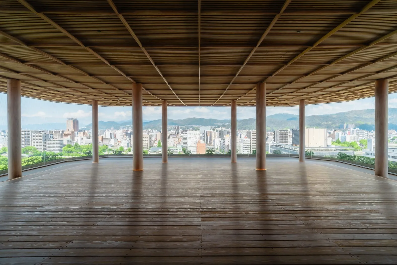 木の柱と天井が広がるおりづるタワーの屋上展望台と広島市街