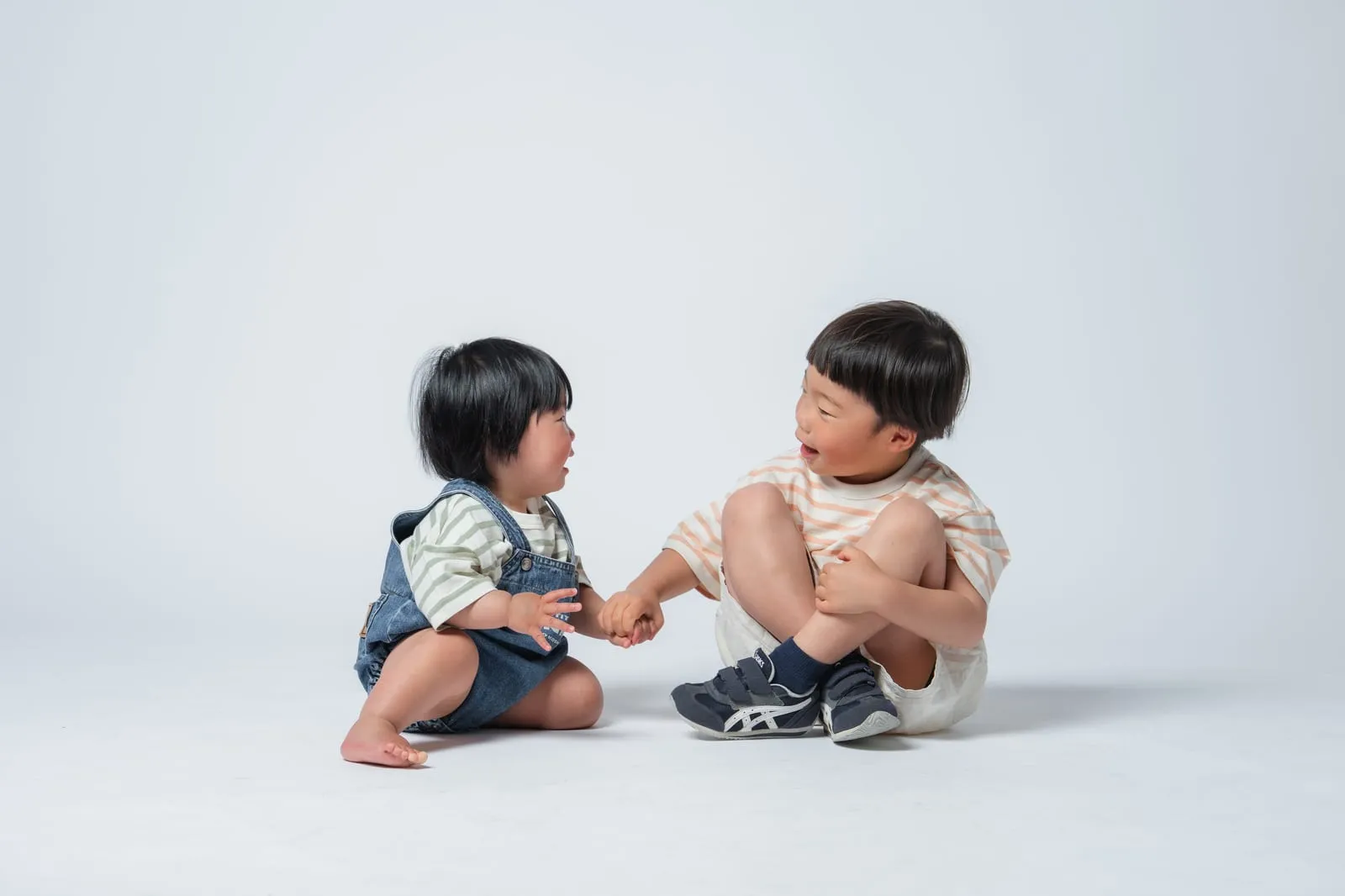 向かい合って座る幼い子どもたち